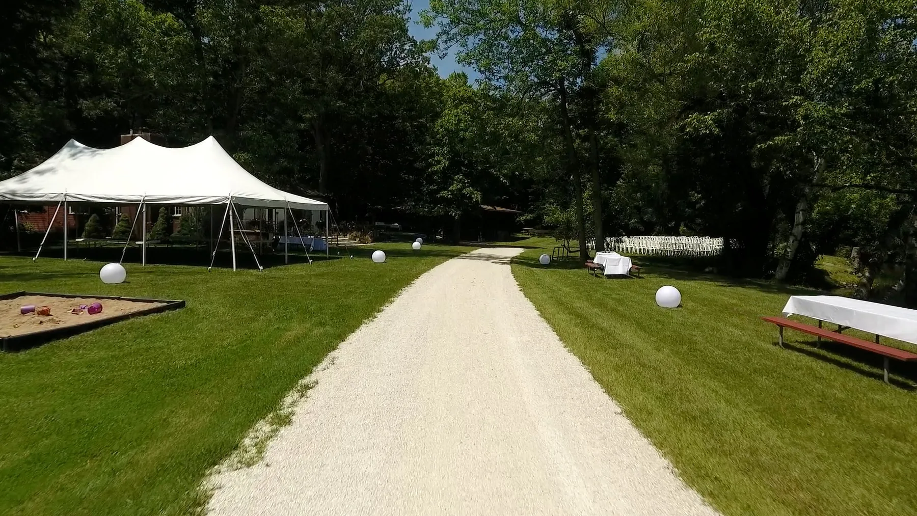 Ceremony seating along a tree-lined path at River Park